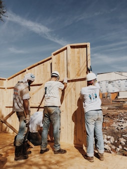 A construction site with workers collaborating on a building project under a clear sky.