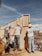 A construction site with workers collaborating on a building project under a clear blue sky.