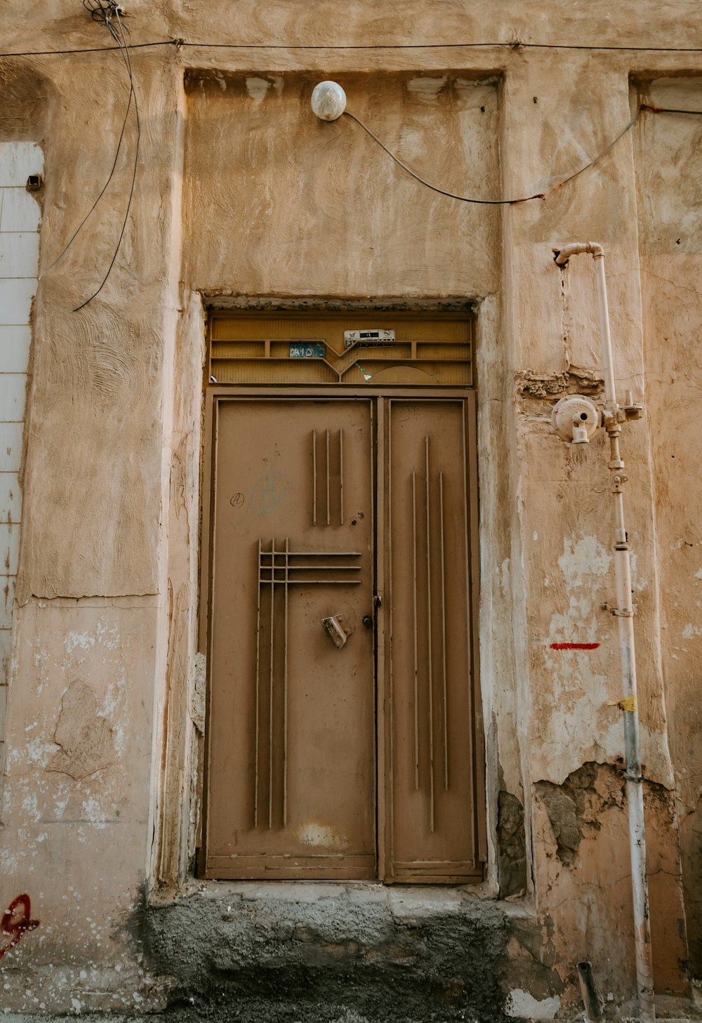 Porta di legno marrone su parete di cemento grigio