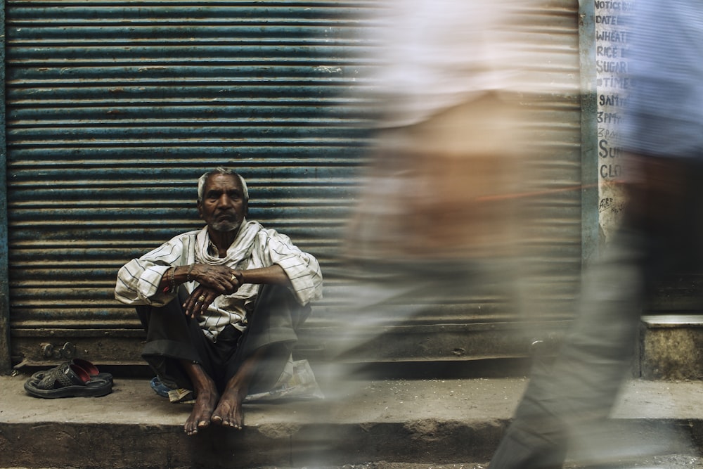 man in white dress shirt sitting on floor