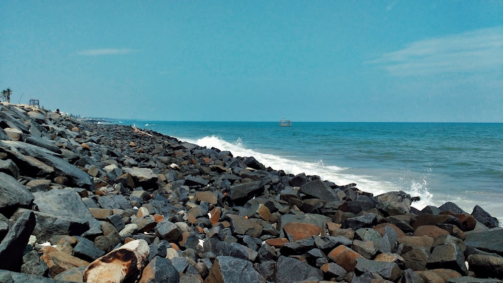 person lying on rocky shore during daytime