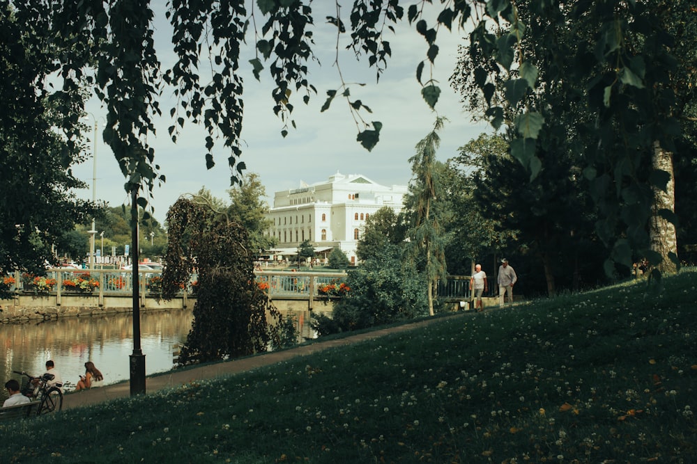 people walking on sidewalk near white concrete building during daytime