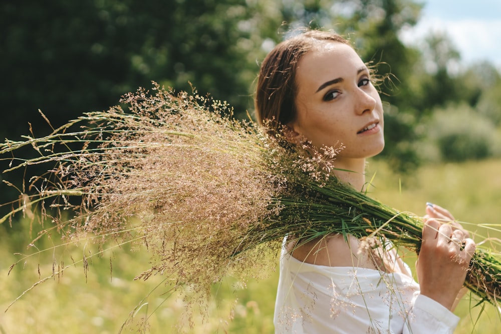 woman in white dress standing on brown grass field during daytime