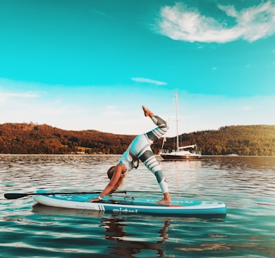 woman in blue and white bikini riding on white surfboard during daytime