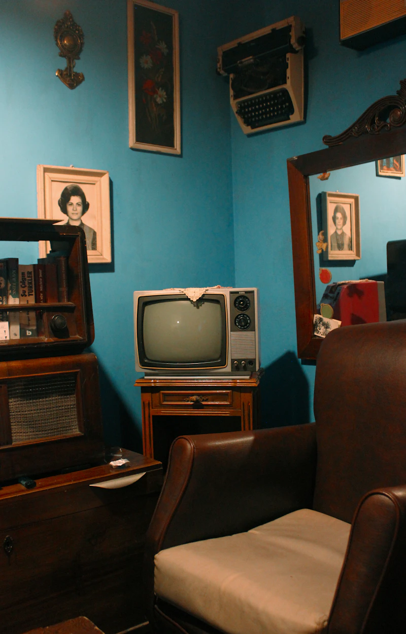 A gray CRT television on a wooden TV stand