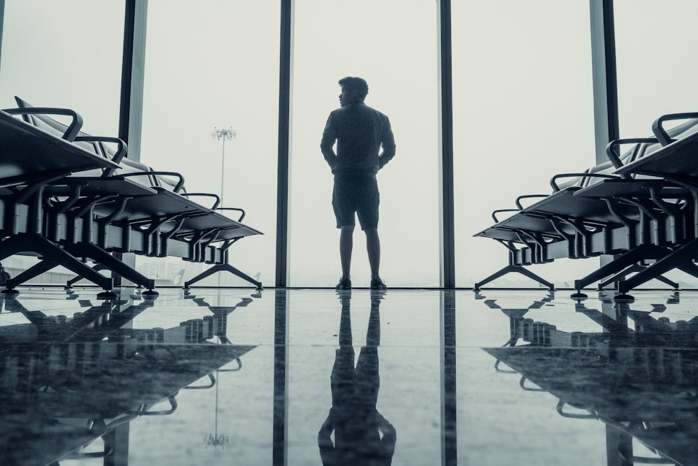 silhouette di uomo in piedi davanti alla finestra di vetro