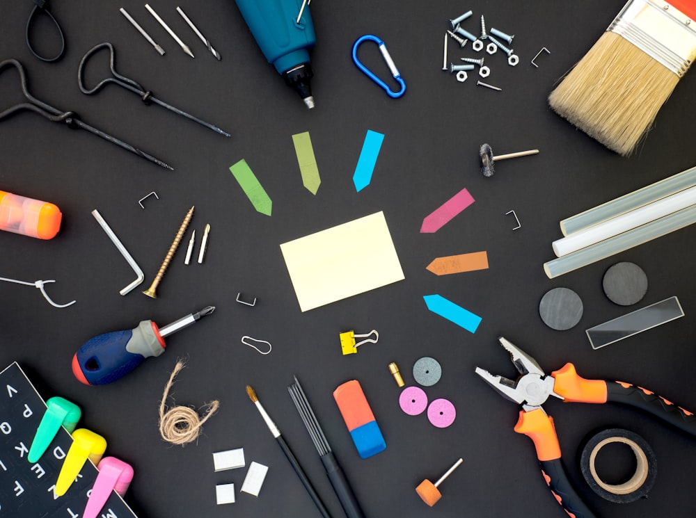 assorted color plastic tools on gray wooden table