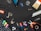A variety of tools and items are arranged against a black background. These include a drill, a paintbrush, screws, drill bits, pliers, an eraser, some markers, a measuring tape, a spool of twine, and several other small hardware items.