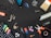 A variety of tools and items are arranged against a black background. These include a drill, a paintbrush, screws, drill bits, pliers, an eraser, some markers, a measuring tape, a spool of twine, and several other small hardware items.