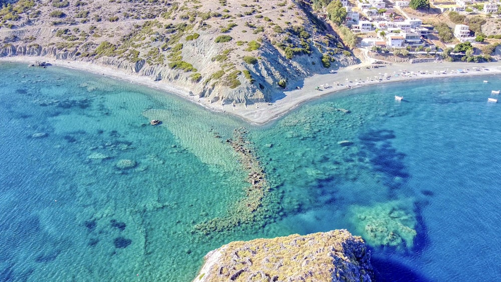 Vista aérea de la montaña verde y marrón junto al mar azul durante el día