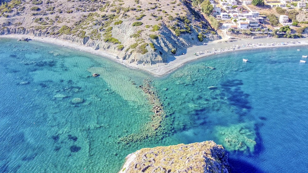 aerial view of green and brown mountain beside blue sea during daytime