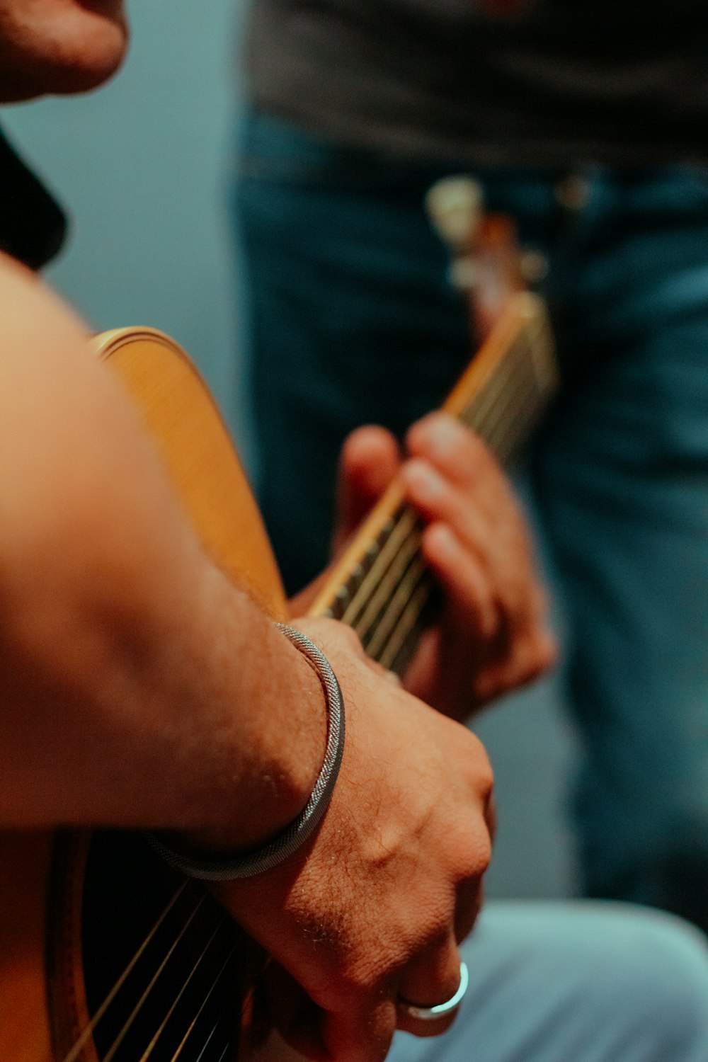 man in black shirt playing brown acoustic guitar