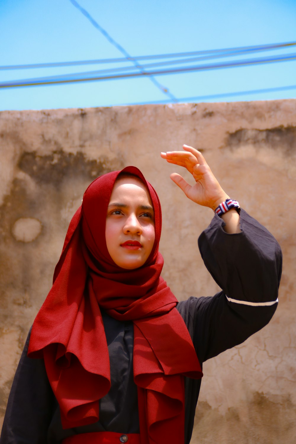 woman in red hijab holding orange fruit