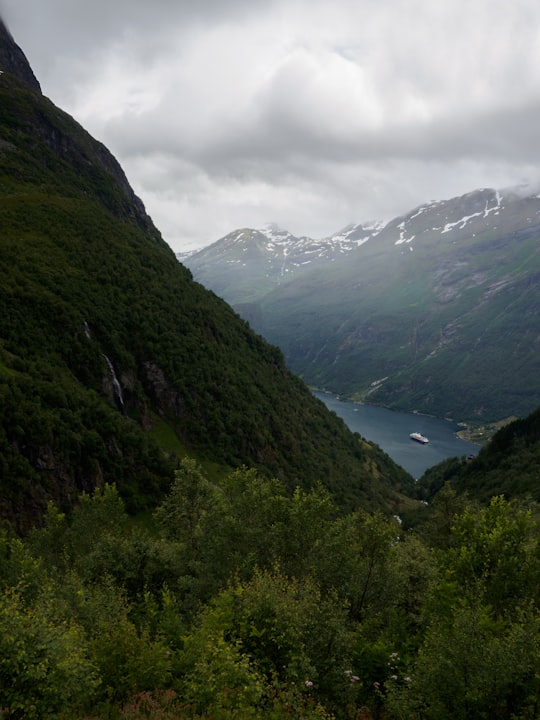 green mountains under white cloudy sky during daytime in Geiranger Norway