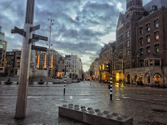 people walking on sidewalk near buildings during daytime in Dam Square Netherlands