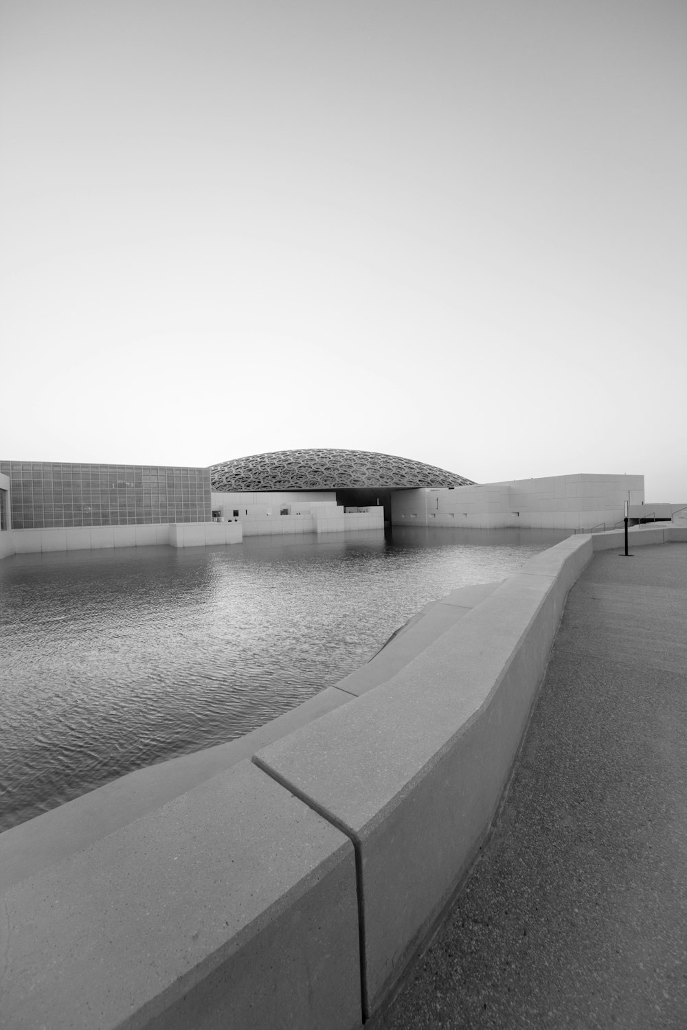 grayscale photo of body of water near building