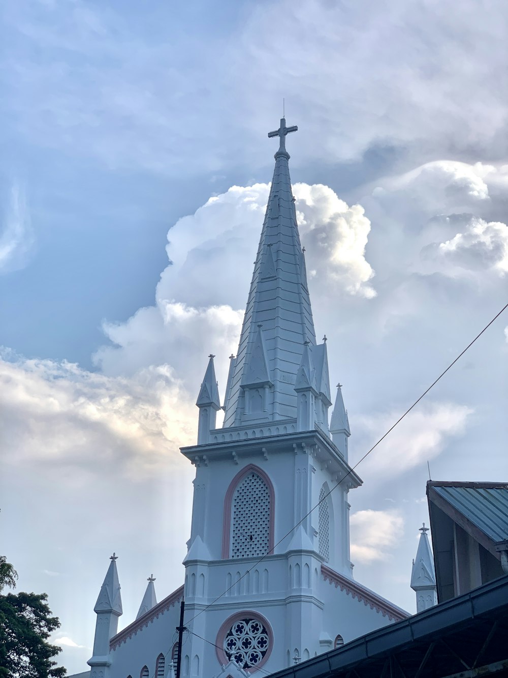 white and black church under white clouds and blue sky during daytime