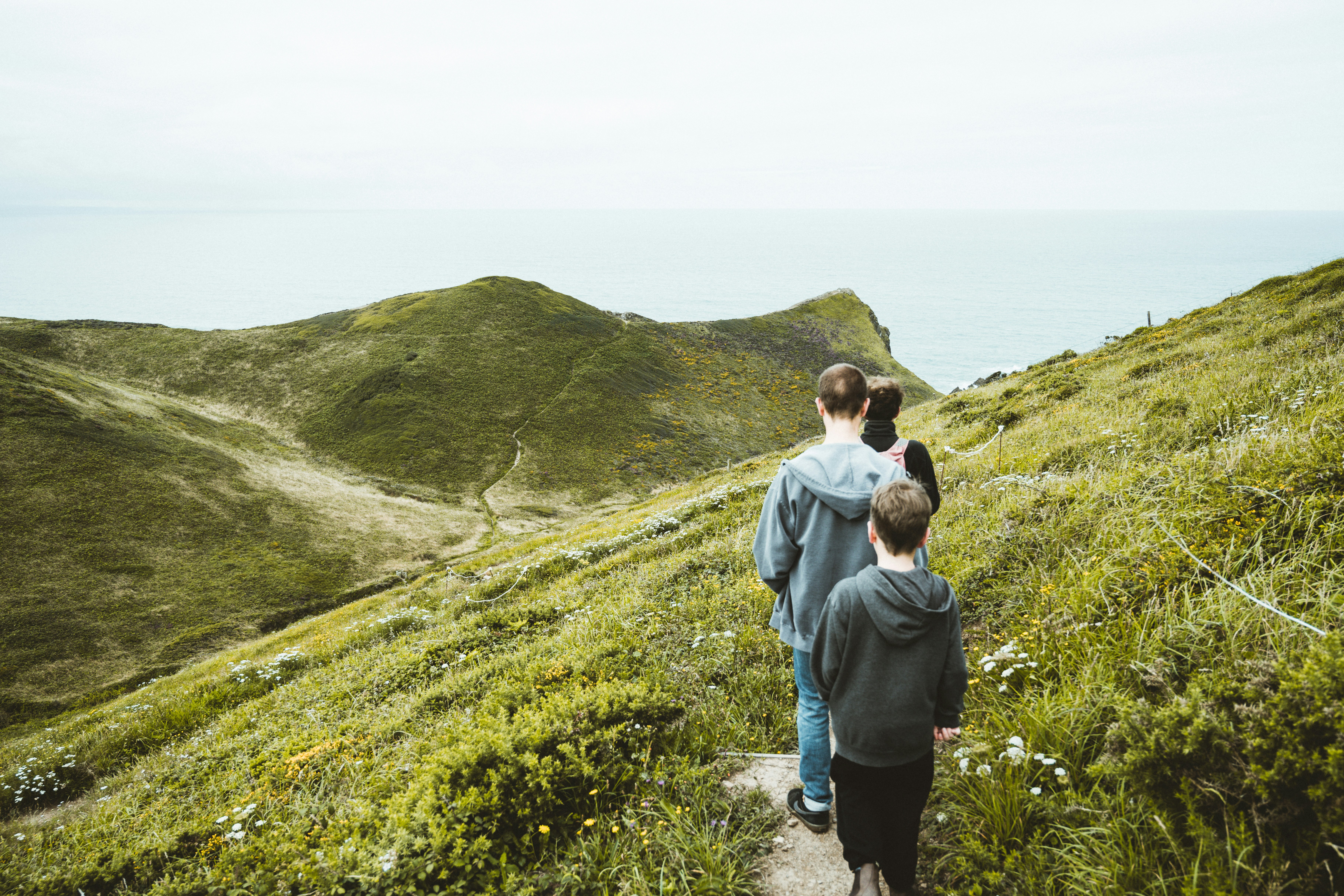 woman in gray jacket standing on green grass field during daytime, 