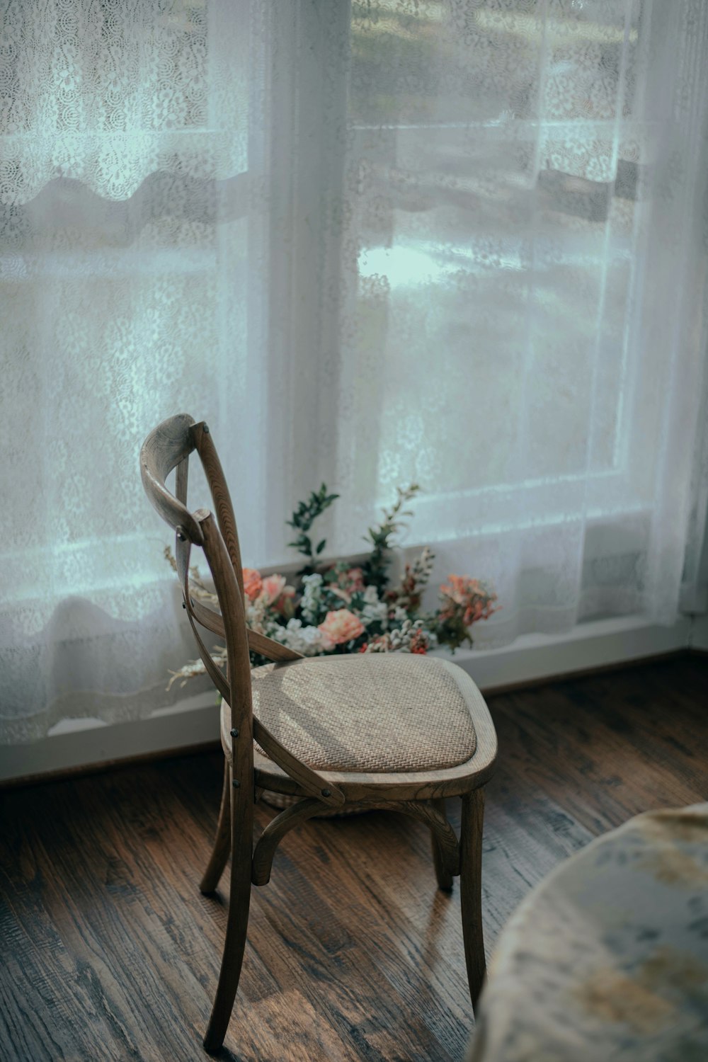 brown wooden chair near white window curtain