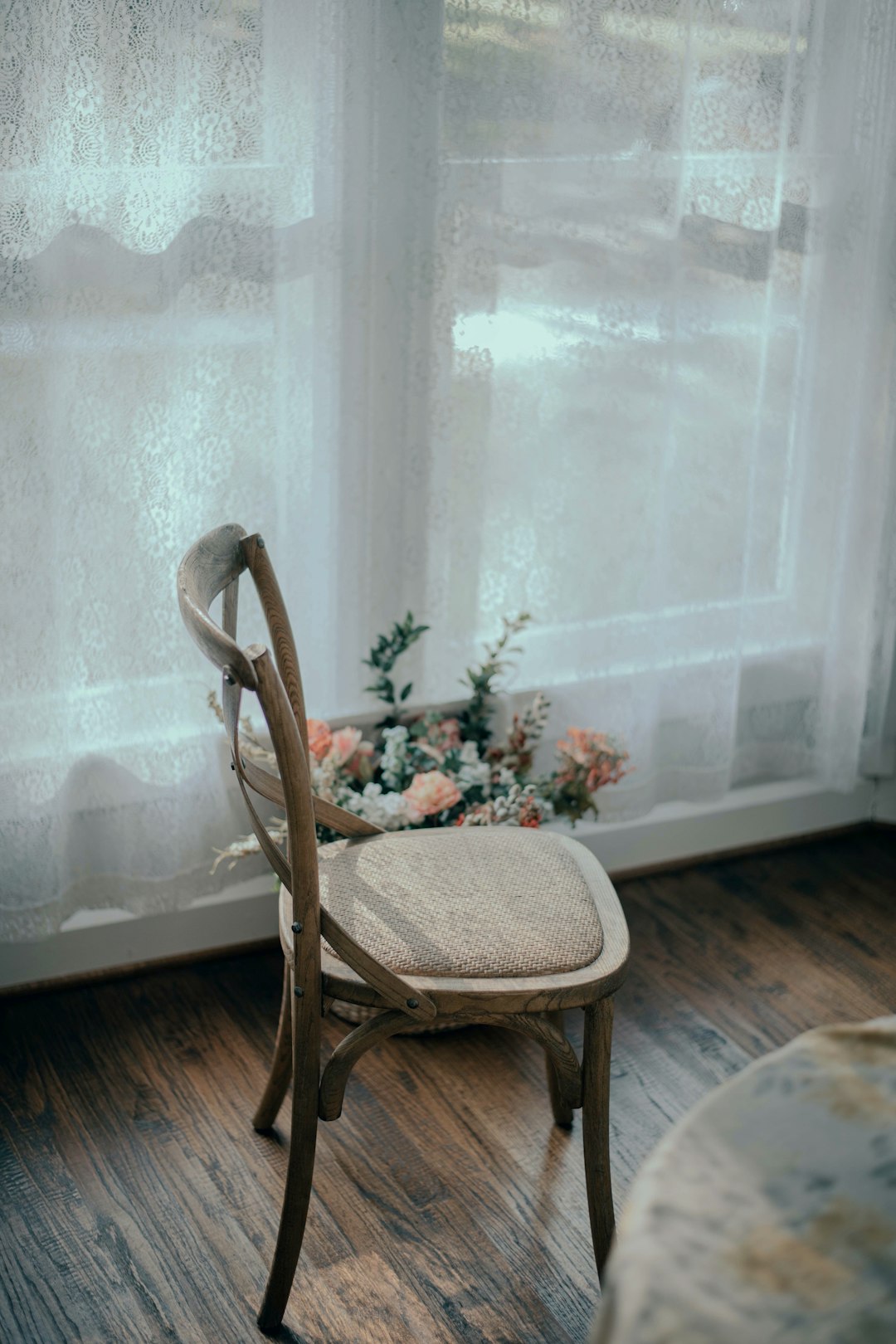 brown wooden chair near white window curtain