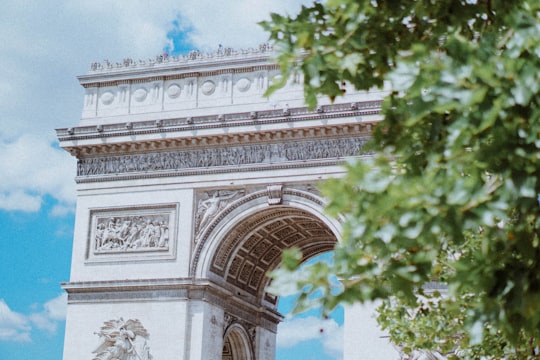 white concrete arch near green trees during daytime in Arc de Triomphe France