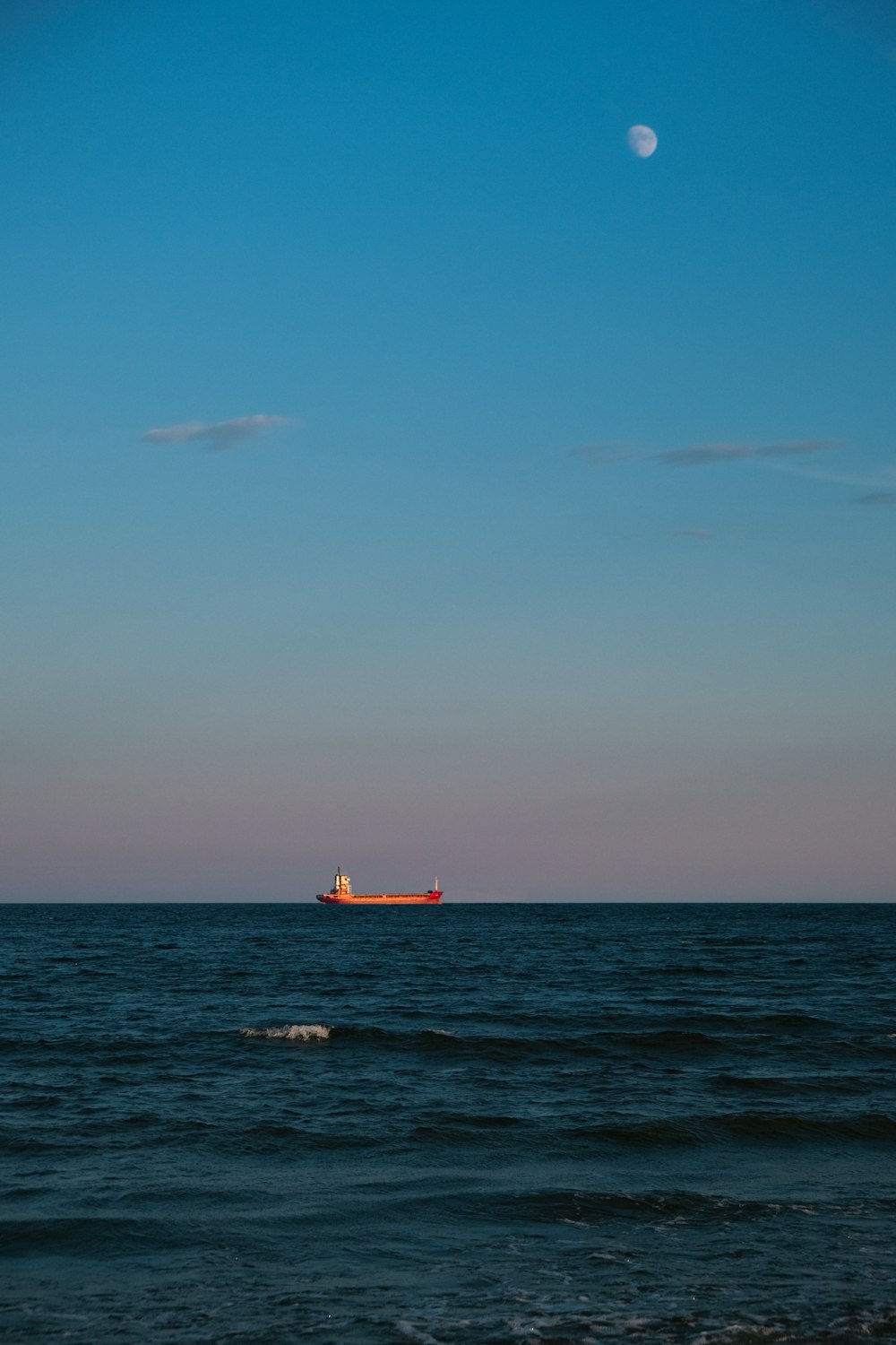 barco vermelho no mar sob o céu azul durante o dia