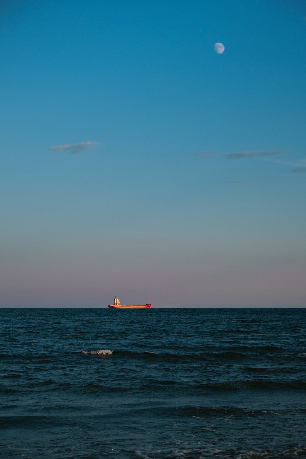 red boat on sea under blue sky during daytime