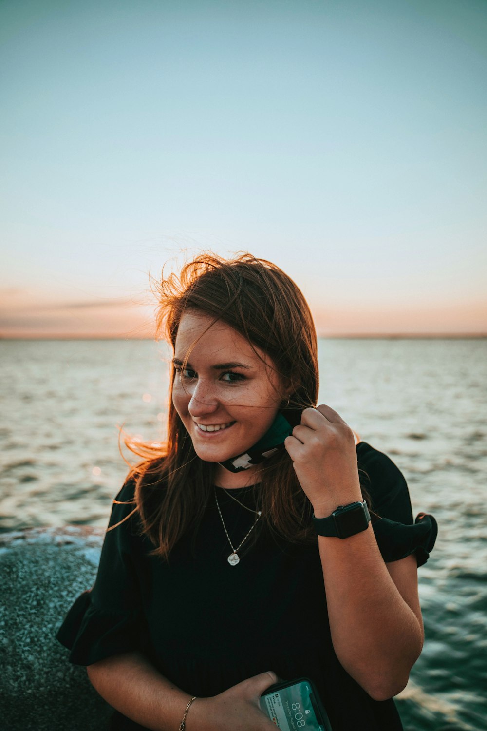 woman in black crew neck shirt holding her face