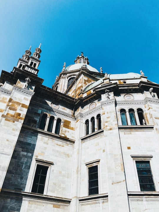 white concrete building under blue sky during daytime in Cathedral of Como Italy