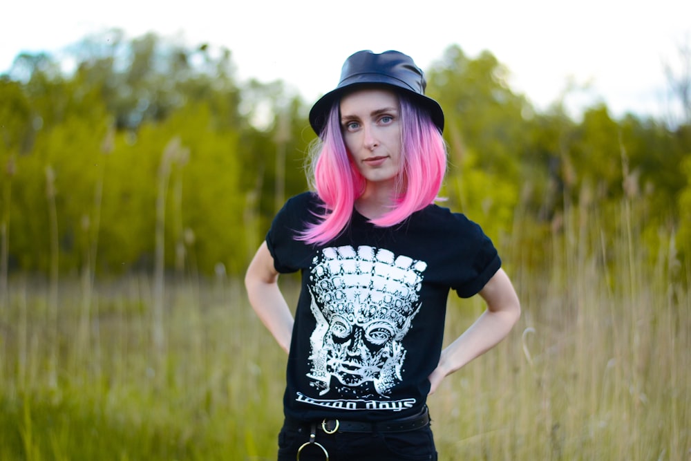 woman in black and white t-shirt standing on green grass field during daytime