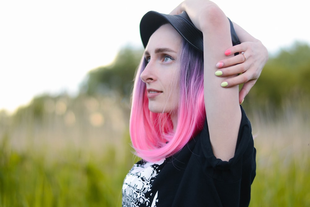 woman in black and white floral shirt with pink hair