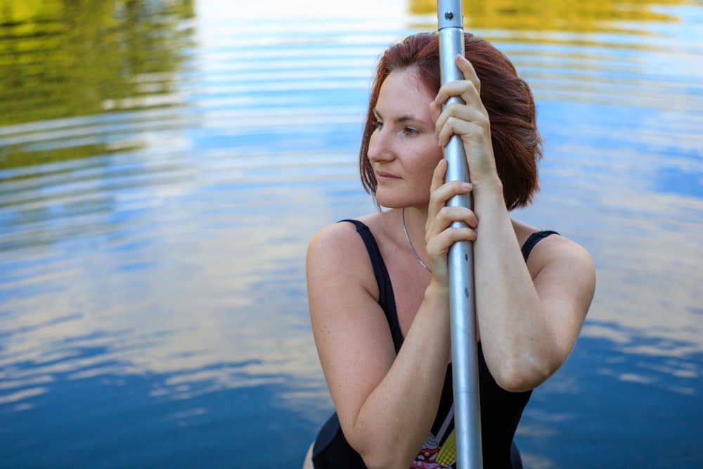 woman in black tank top and black leggings sitting on blue and silver ladder