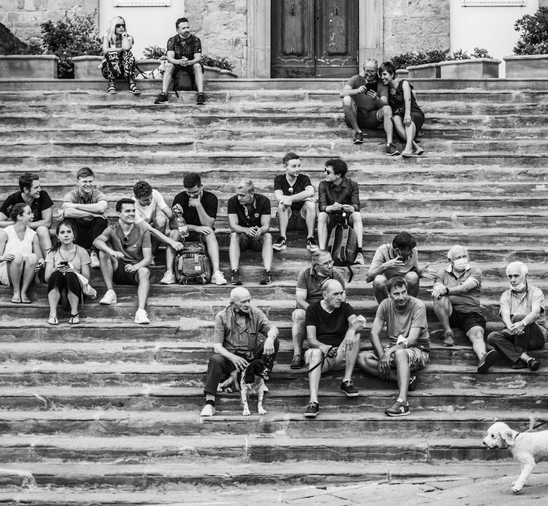 grayscale photo of children sitting on stairs
