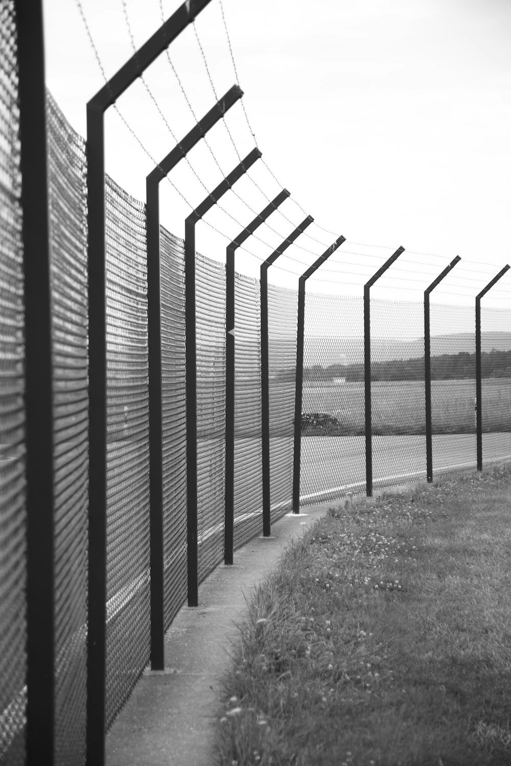 grayscale photo of metal fence