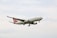 A cargo airplane with the branding 'Turkish Cargo' is flying in the sky. The aircraft is primarily white with red accents on its tail fin. The sky is overcast with light clouds.