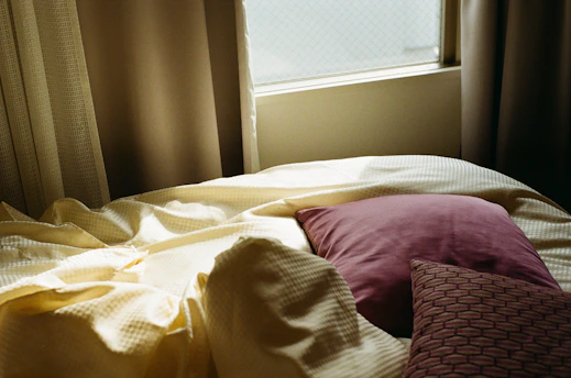 A cozy bedroom scene featuring a custom mattress with soft pastel bedding.