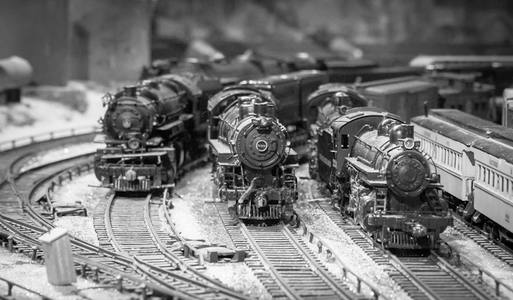 A vibrant photo of a detailed model railroad layout featuring trains winding through miniature landscapes.