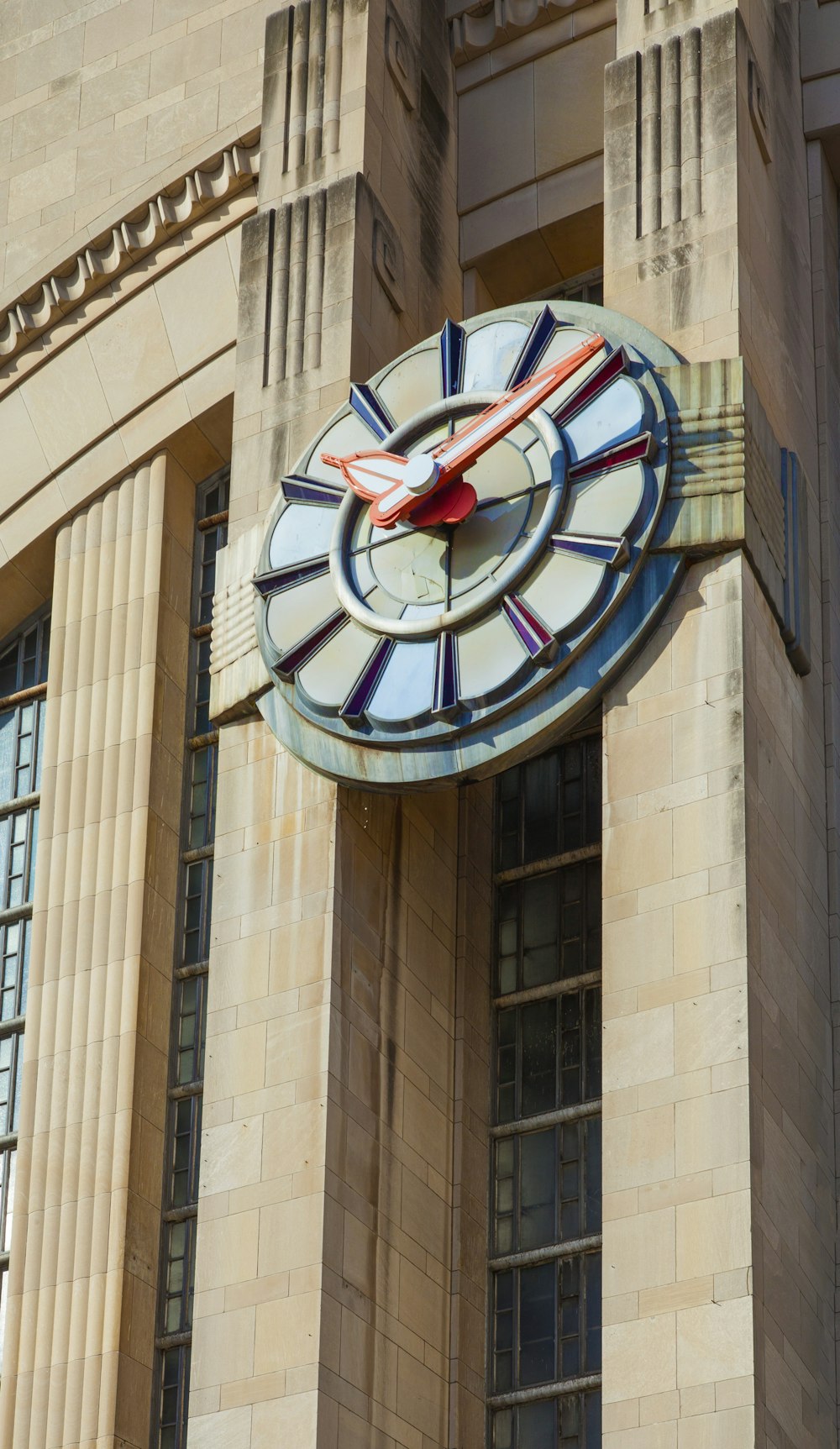 round black and red analog clock at 11 00