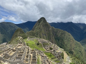 aerial view of green mountains under cloudy sky during daytime