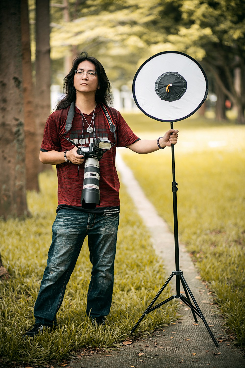 woman in red and white plaid shirt and blue denim jeans holding black and white camera