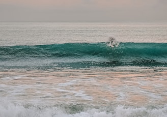 person surfing on sea waves during daytime