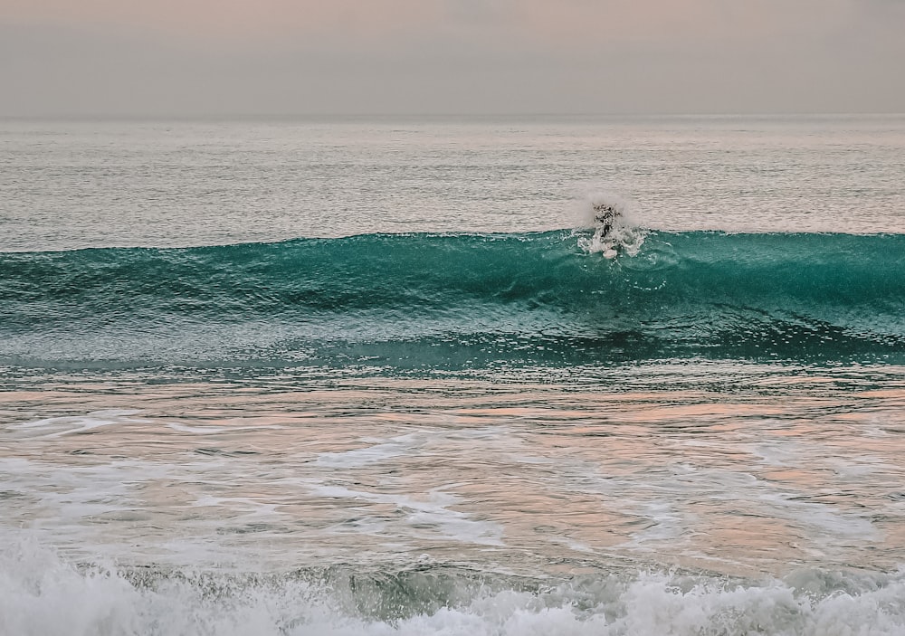 person surfing on sea waves during daytime