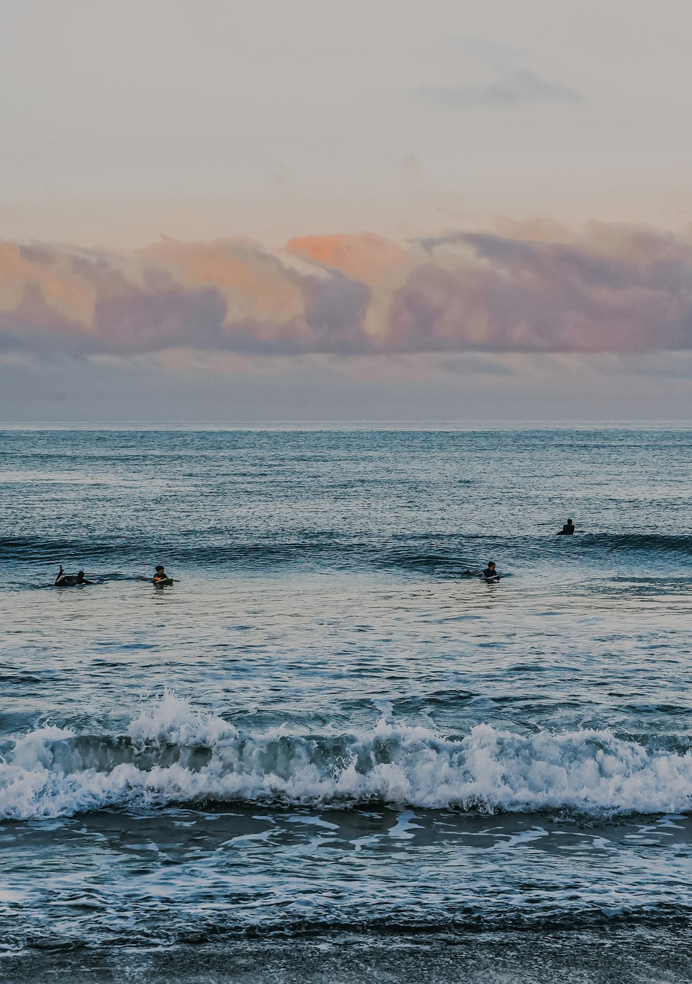 people surfing on sea waves during daytime