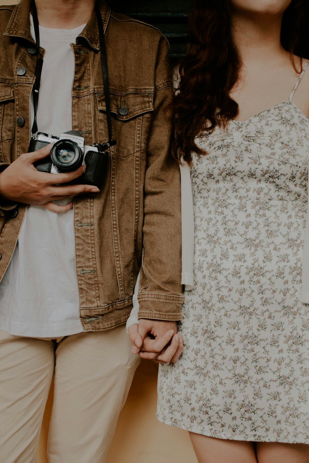 woman in beige long sleeve shirt holding black and silver camera