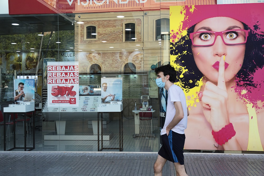 woman in white shirt and black skirt standing near glass window