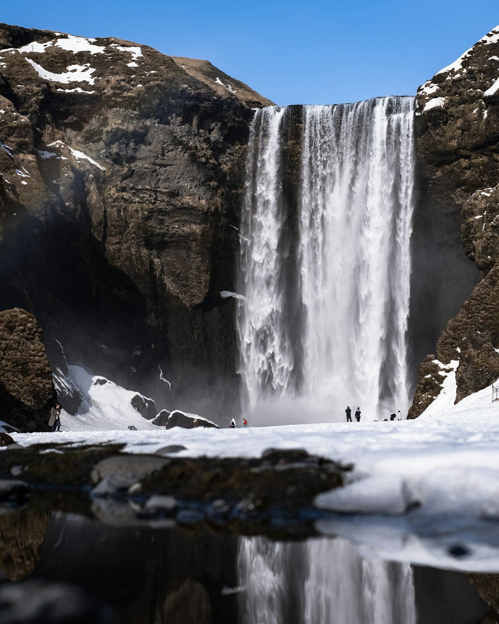 waterfalls on brown rocky mountain during daytime