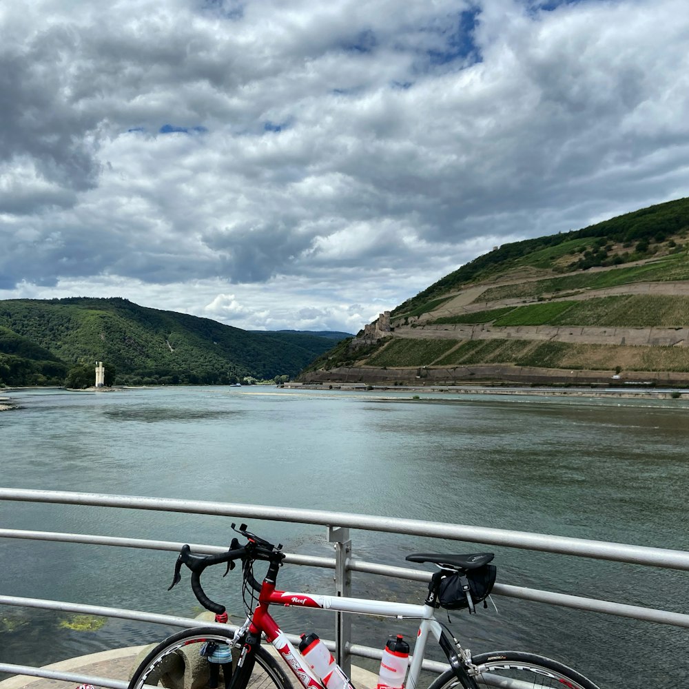 red and white bicycle on road near body of water during daytime