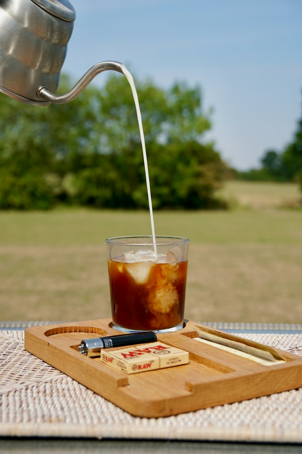 clear drinking glass with brown liquid on brown wooden table