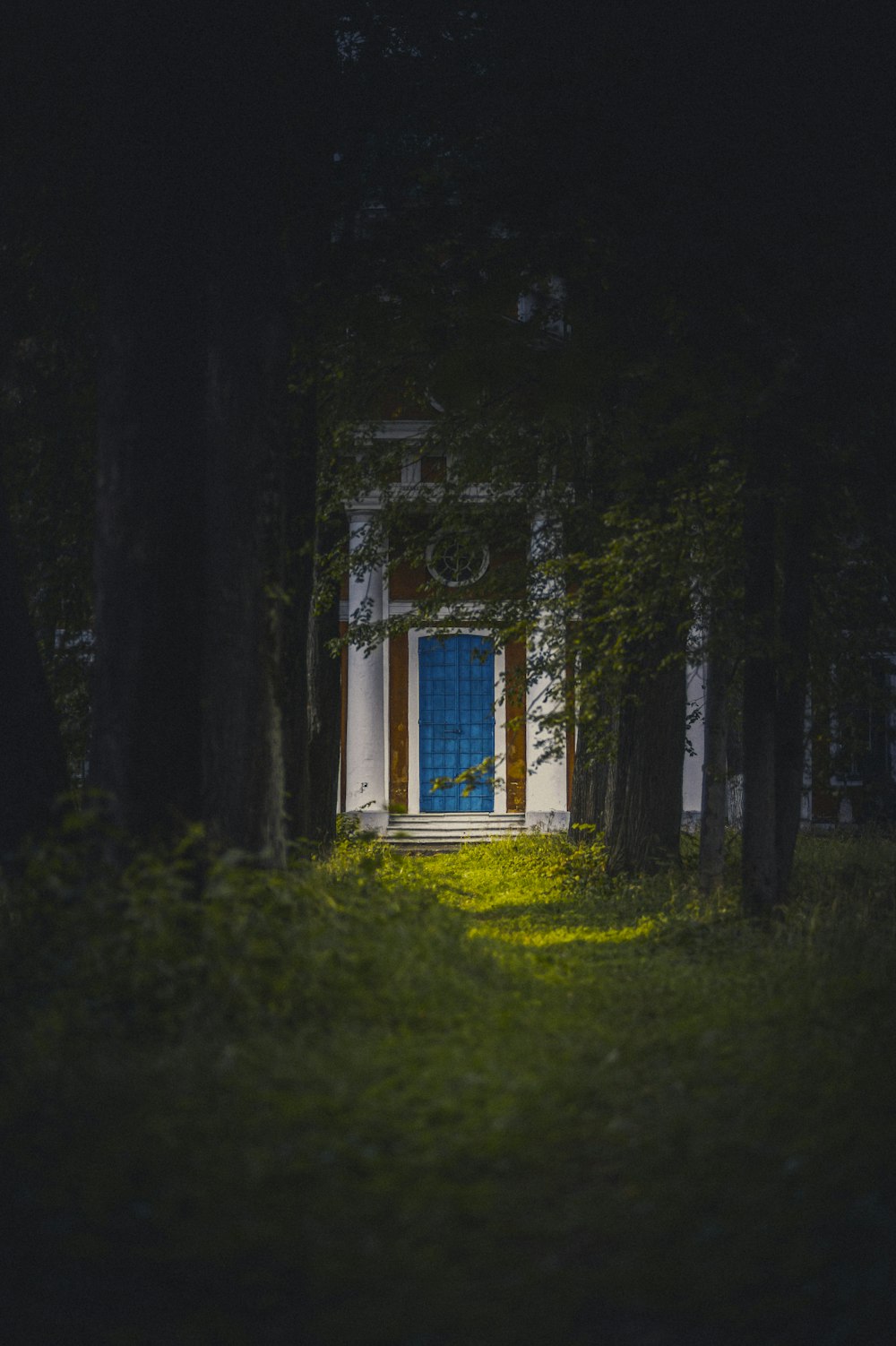 white and blue wooden house on green grass field