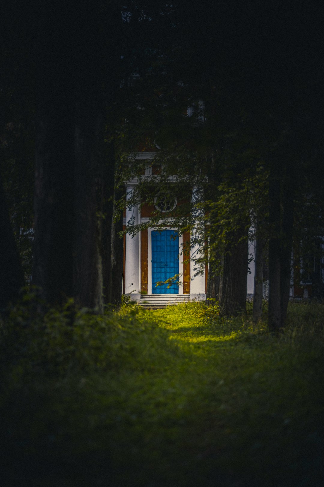 white and blue wooden house on green grass field